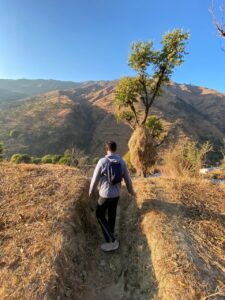 A boy walking through a terrace farm in the Himalayas